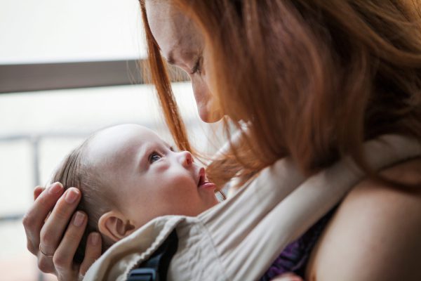 Mother embracing baby girl (6-11 months)